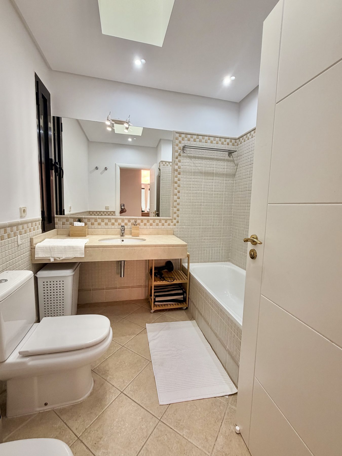 En-suite bathroom with bath and skylight