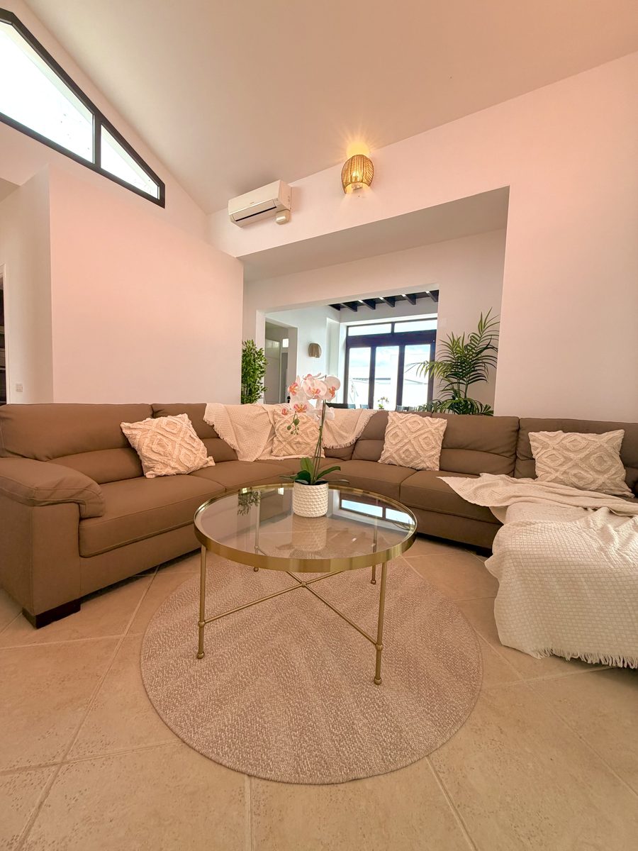 Open-plan living space with corner sofa and gold coffee table